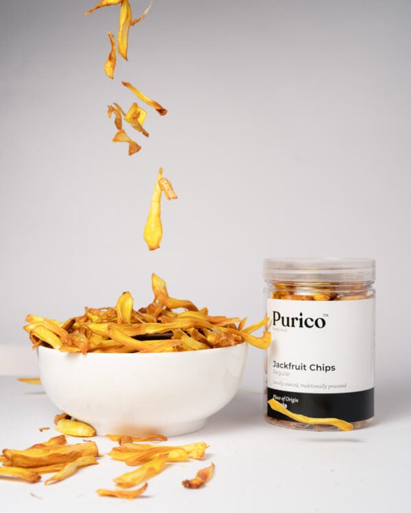 Jackfruit chips falling into bowl with jar beside