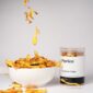 Jackfruit chips falling into bowl with jar beside